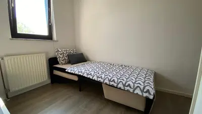 a small bed in a room with a window at Apartma Nomad in Novo Mesto