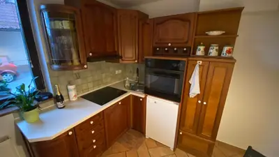 a kitchen with wooden cabinets and white counter tops at Apartma Nomad in Novo Mesto