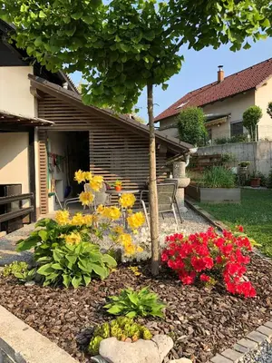 a garden with flowers in front of a house at Apartma Nomad in Novo Mesto