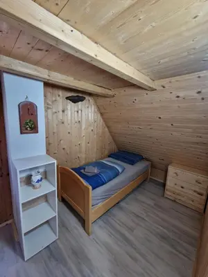 a bedroom with a bed in a wooden cabin at OTO`S CABIN in Radovljica