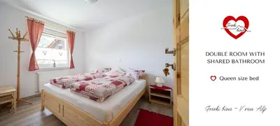 a bedroom with a bed with red and white pillows at Gorski biser in Mojstrana