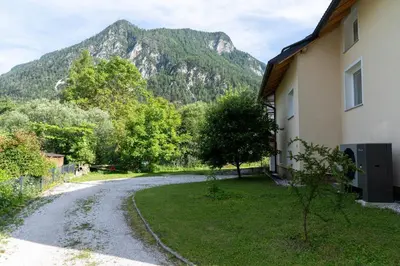 a house and a road with a mountain in the background at Gorski biser in Mojstrana