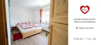a small bedroom with a bed and a door at Gorski biser in Mojstrana