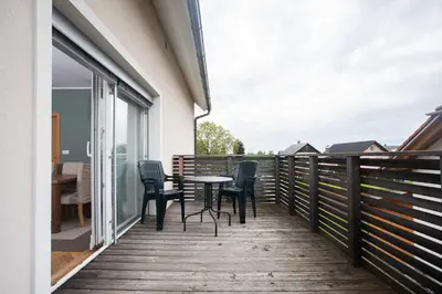 a wooden deck with chairs and a table on it at Apartment Rozalija Žirovnica in Žirovnica