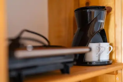 a coffee maker and a coffee cup on a shelf at Apartma Metka in Bohinj