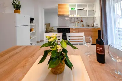 a dining room table with a bottle of wine and a plant at Apartma na hribu in Mojstrana
