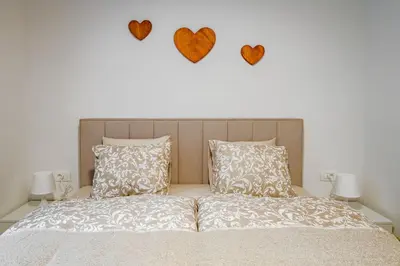 a bedroom with a bed with hearts on the wall at Apartma na hribu in Mojstrana