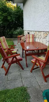 a group of chairs and a wooden picnic table at Apartma Sabatuš in Bohinj