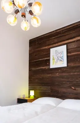 a bedroom with a wooden headboard and a white bed at Passero Holiday House in Moravske Toplice
