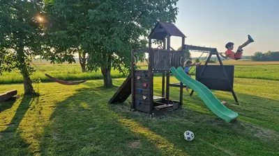a boy is playing on a playground with a slide at Passero Holiday House in Moravske Toplice