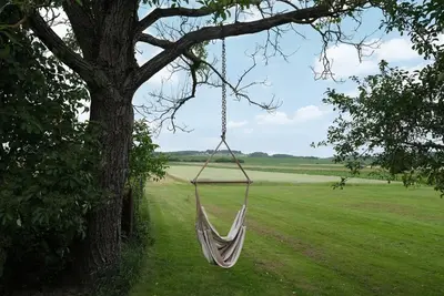 a hammock hanging from a tree in a field at Passero Holiday House in Moravske Toplice