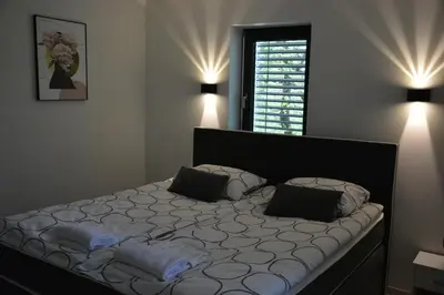 a bedroom with a bed with two pillows on it at House Under The Maple Tree in Vitanje