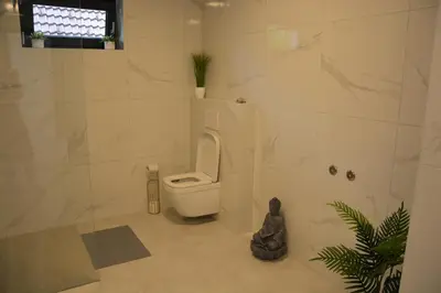 a bathroom with a toilet and a plant in it at House Under The Maple Tree in Vitanje