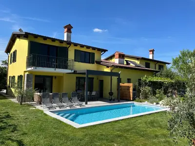 a villa with a swimming pool in front of a house at Holiday house Oljka in Kobdilj