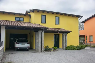 a yellow house with a car parked in the garage at Holiday house Oljka in Kobdilj