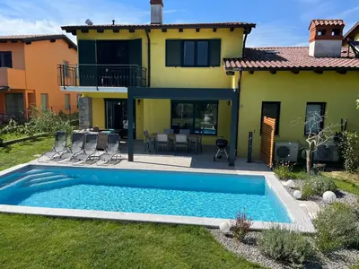 a villa with a swimming pool in front of a house at Holiday house Oljka in Kobdilj