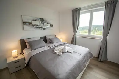 a bedroom with a large bed with a bow on it at Holiday house Oljka in Kobdilj