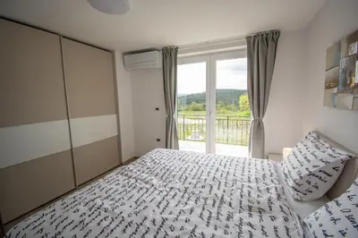 a bedroom with a bed and a large window at Holiday house Oljka in Kobdilj