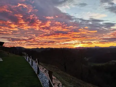 a sunset on top of a hill with a fence at Hill Cottage Haloze in Gruškovec