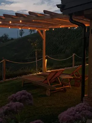a wooden pergola with two chairs and a swing at Hill Cottage Haloze in Gruškovec