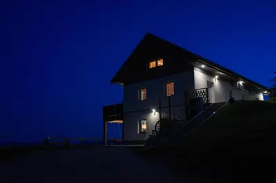 a house with lights on the side of it at night at Apartmaji Gračner in Dramlje