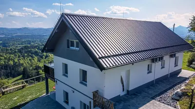 a white house with a black roof with a view at Apartmaji Gračner in Dramlje