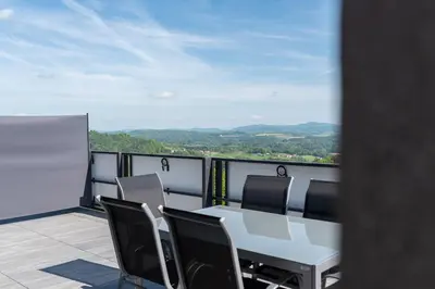 a table and chairs on a balcony with a view at Apartmaji Gračner in Dramlje