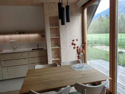 a kitchen and dining room with a table and a window at Tiny Eko House Bovec in Bovec