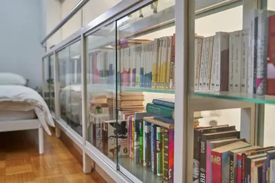 a room with glass shelves filled with books at Matic Spacious Modern Apartment in Ljubljana