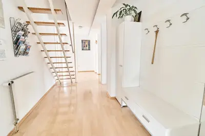 a hallway with white walls and a spiral staircase at Matic Spacious Modern Apartment in Ljubljana