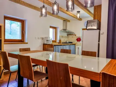 a kitchen with a table and chairs and a refrigerator at Jakob Cabin in Bovec