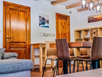a living room with a wooden table and chairs at Jakob Cabin in Bovec