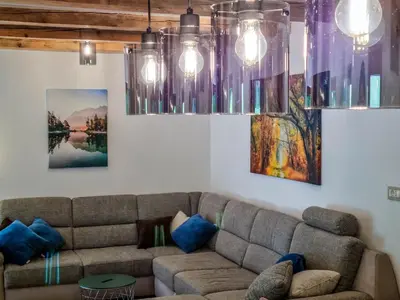 a living room with a couch and two paintings at Jakob Cabin in Bovec