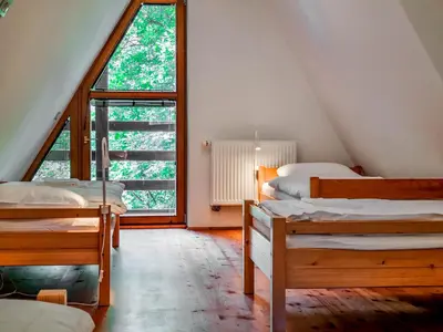 a attic room with three beds and a large window at Jakob Cabin in Bovec