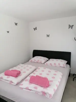 two beds with pink and white pillows on them at Pri stari preši in Lendava