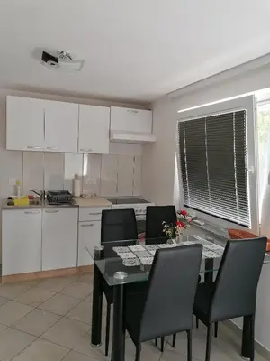 a kitchen with a dining room table and chairs at Pri stari preši in Lendava