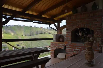a room with a brick fireplace with a bench and a table at Pri stari preši in Lendava
