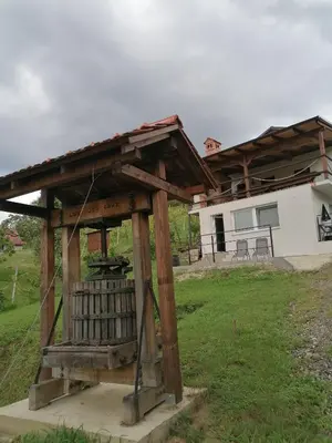 a wooden pavilion in a yard in front of a house at Pri stari preši in Lendava