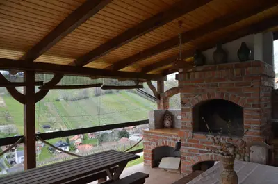 a brick fireplace with a view of a field at Pri stari preši in Lendava