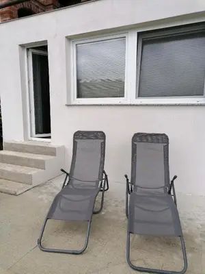 two chairs sitting on a patio in front of a house at Pri stari preši in Lendava
