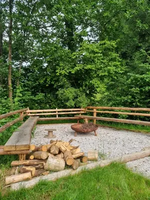 a garden with a pile of logs and a wooden fence at GREEN LAND Family Fun Sport Resort in Šmarje pri Jelšah