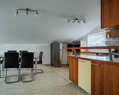 a kitchen with a table and black chairs in it at Apartma Hilltop Haven in Šmarje pri Jelšah