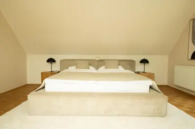 a bedroom with a large white bed with two lamps at An der Südsteirischen Weinstraße Gamlitz - Idyllisches Ferienhäuschen im Naturparadies mit großem Whirlpool & Panoramasauna in Zgornja Kungota