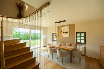 a dining room with a table and chairs and stairs at An der Südsteirischen Weinstraße Gamlitz - Idyllisches Ferienhäuschen im Naturparadies mit großem Whirlpool & Panoramasauna in Zgornja Kungota