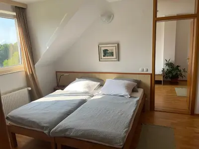 two twin beds in a room with a window at Karla’s House in Dobje pri Planini