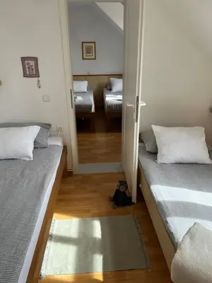 a small room with two beds and a mirror at Karla’s House in Dobje pri Planini