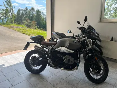 a black motorcycle parked in a room with a window at Karla’s House in Dobje pri Planini