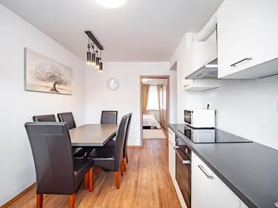 a kitchen and dining room with a table and chairs at Grand Family Residence Ljubljana in Ljubljana