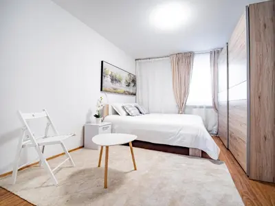 a bedroom with a bed and a table and a chair at Grand Family Residence Ljubljana in Ljubljana