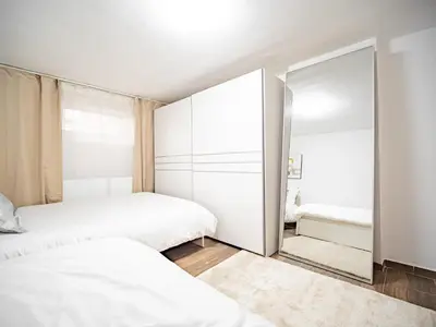 a bedroom with two beds and a mirror at Grand Family Residence Ljubljana in Ljubljana